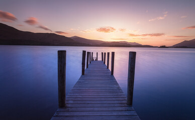 Long exposure post sunset of wooden jetty leading into a lake.  Lake District Uk. Feelings of calm and relaxation