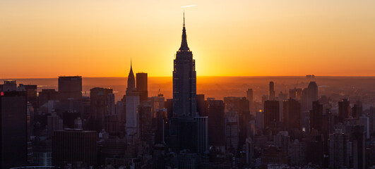 Manhattan Skyline Empire State at sunrise, beautiful morning glow with warm sun, Silhouette 
