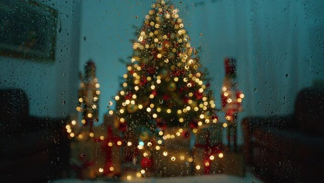 Christmas tree over a wet window from rain in the house