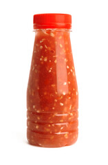 red sauce in a transparent bottle with a red lid on a white background