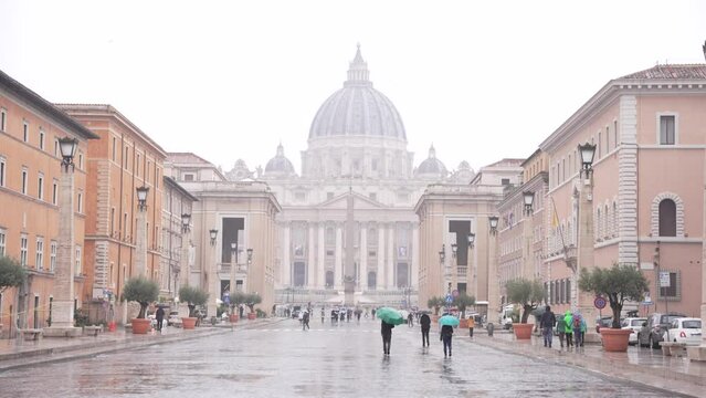 People walking towards St Peter's Basilica in the Rain. Rome, Italy. 