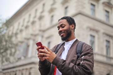 portrait of a young man in the street while using a smartphone
