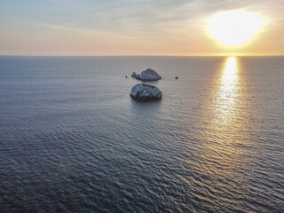 Toma aérea con drone de una atardecer con islas pequeñas blancas de fondo en el océano pacifico 