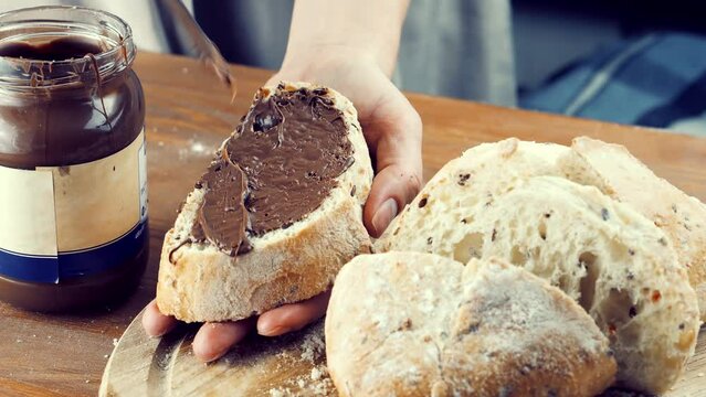 woman spreading chocolate spread on bread