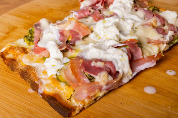 Pinsa Romana con stracciata di bufala, zucchine e pancetta croccante appena sfornata in una...