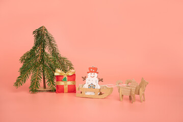 Creative Christmas card. diy snowman in sleigh. concept of new year and holiday. pink background.