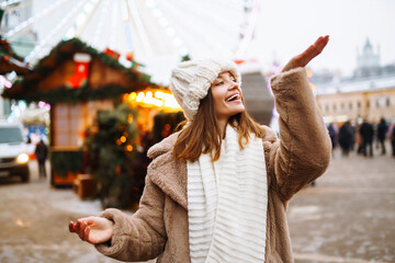 Happy woman with disposable paper coffee cup in winter over outdoor ice skating rink on background. Christmas, hot drinks and holidays concept.