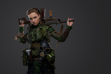 Portrait of female soldier after armageddon holding self made shotgun on her shoulders.