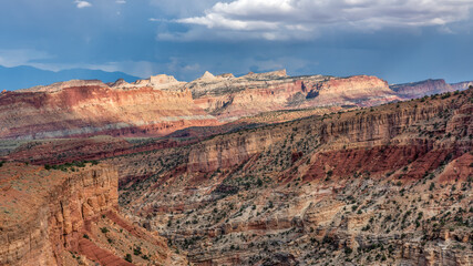 Dramatic evening lighting on the canyon from Sunset Point at the Capitol Reek National Park mountains in the distance 