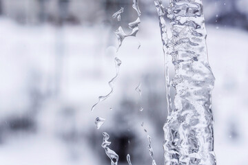 Winter background. A stream of water frozen on the window in the cold season.