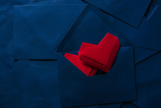 Red paper heart and blue envelope,Love letter idea with blue envelope with red hearts spilling out.
