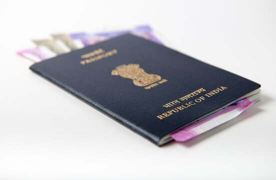 Indian currency notes inserted in the passport book. Close up of official Indian passport booklet with Indian rupee notes.