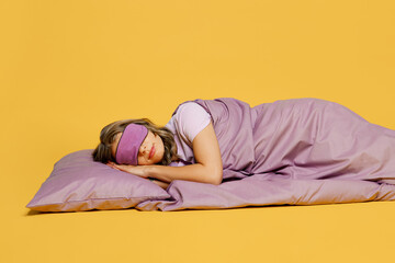 Full body young calm tranquil woman wearing purple pyjamas jam sleep eye mask rest relax at home...