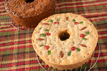 Homemade dark and light fruitcakes fresh out of the oven and cooling on baking racks.