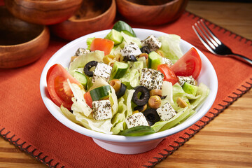 Greek Salad with tomato, cucumber, olive and herbs served in dish isolated on table side view of middle east food