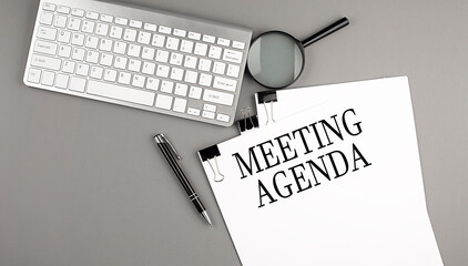MEETING AGENDA text on paper with keyboard, magnifier and pen. Business concept
