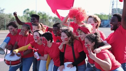 Group of fans with all kinds of accessories cheering their team with great joy and passion