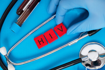 The inscription HIV with wooden letters on a colored background.