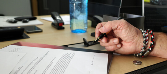 Male hand with fountain pen about to sign a contract