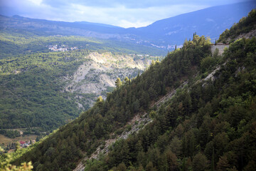 Fototapeta na wymiar A glimpse of the Aventino valley between the slopes of the steep green tree-lined mountains, Lama dei Peligni, Abruzzo, Italy