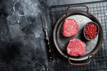 Dry aged Raw steaks fillet Mignon, Beef tenderloin. Black background. Top view. Space for text