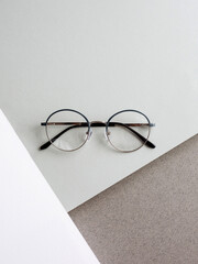 thin grey frame glasses on grey white background