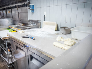 Dough and flour on countertop in commercial kitchen