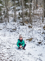 Fototapeta na wymiar Boy playing with snow in forest
