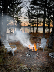 Empty chairs and bonfire in forest