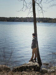 Side view of boy standing at lakeshore