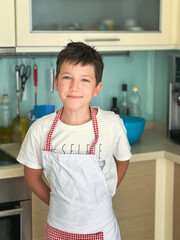 Smiling boy wearing apron in kitchen at home