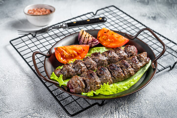 Grilled Adana kebab served with tomato, salad and onion. White background. Top view. Copy space