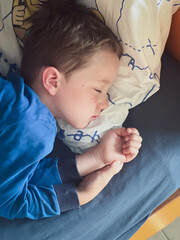 Boy sleeping on bed at home