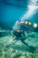 Father and scuba diving together in ocean