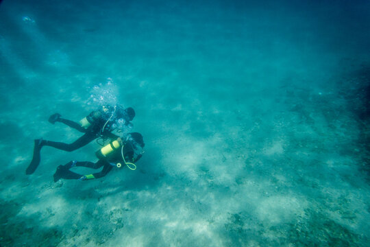Son and father scuba diving in ocean