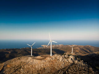 Wind turbines on mountain against blue sky