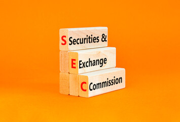 SEC securities and exchange commission symbol. Concept words SEC securities and exchange commission on wooden blocks on beautiful orange background. Business SEC securities exchange commission concept