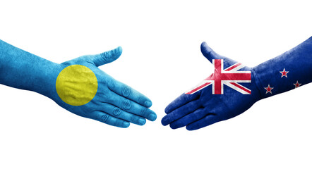 Handshake between New Zealand and Palau flags painted on hands, isolated transparent image.