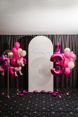 Birthday party decorated with pink, violet balloons in the style unicorn, rainbow, my little pony. Idea for decorating party. Reception. Copy space. Birthday arch for 3 years and a photo wall.