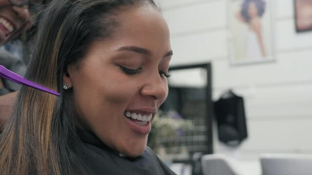Close-up of woman having her hair braided by hairdresser in hair salon