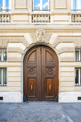 Paris, an ancient door, beautiful facade in a luxury neighborhood, rue Saint-Dominique, in the 7e arrondissement
