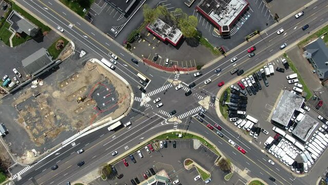 4K. Shooting from top to bottom, cars moving, driving along a multi-lane intersection of roads, urban landscape. Road transport. Buildings near the road.