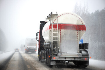 Blurred background of truck on highway in winter. Freight transportation, fuel transportation