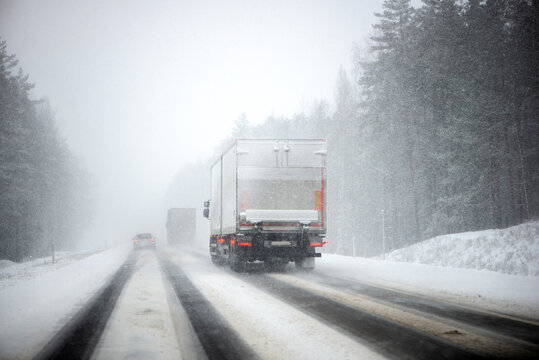 Blurred background of a moving truck on a highway in winter. Freight transport, transportation of goods.