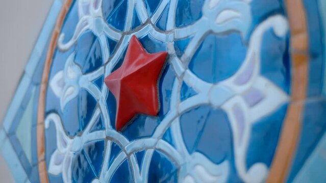 Beautiful colorful ceramic tiles with oriental type floral pattern glisten with voluminous textures and reflect the surroundings. Closeup. Shot in motion