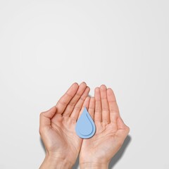 Blue water drop in human hands