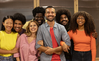Multiracial group of seven smiling friends looking at the camera. Ethnic diversity concept