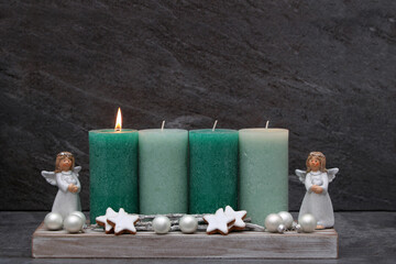 Fotoserie zur Adventszeit: Schlichte Adventsdekoration mit grünen Kerzen, Engel und Zimtsternen.