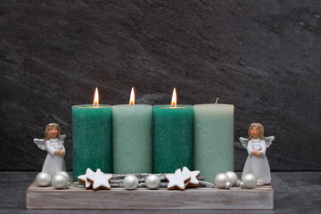 Fotoserie zur Adventszeit: Schlichte Adventsdekoration mit grünen Kerzen, Engel und Zimtsternen.