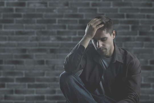 Abused sad man hide herself in dark background